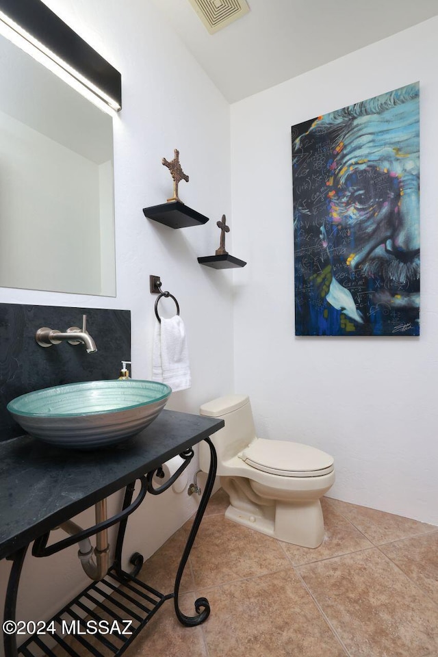 bathroom featuring toilet, tile patterned floors, and sink