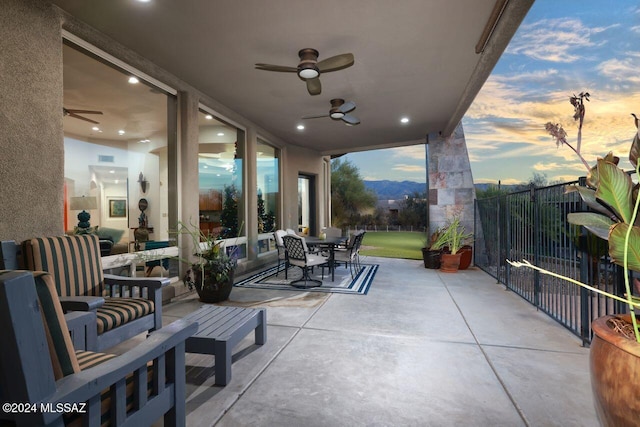 patio terrace at dusk featuring ceiling fan