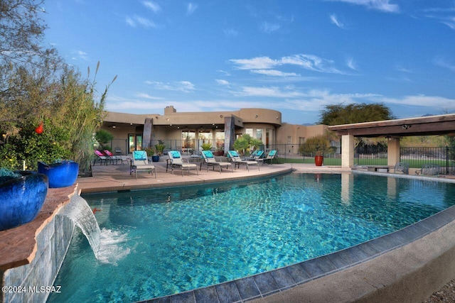 view of swimming pool featuring pool water feature and a patio