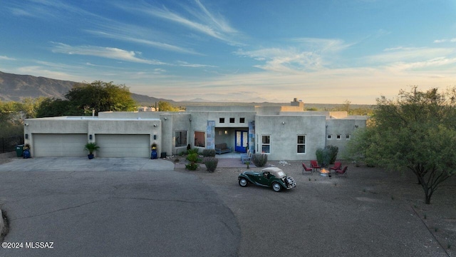 pueblo revival-style home with a mountain view and a garage