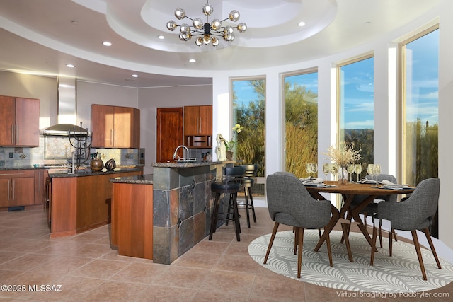 kitchen with tasteful backsplash, brown cabinets, a peninsula, and island range hood