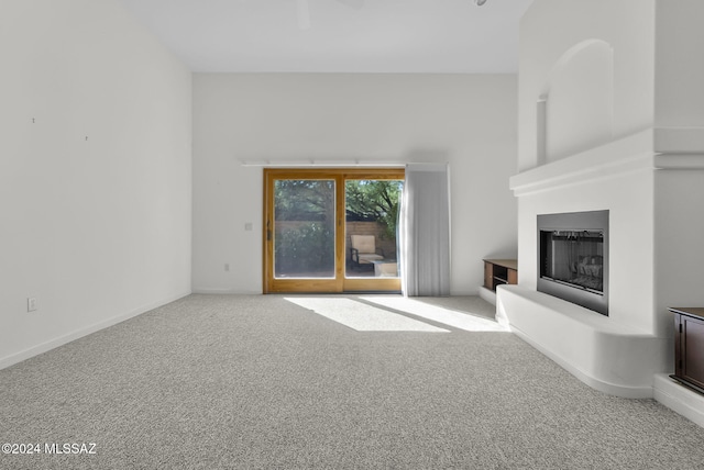 unfurnished living room featuring carpet flooring and a large fireplace