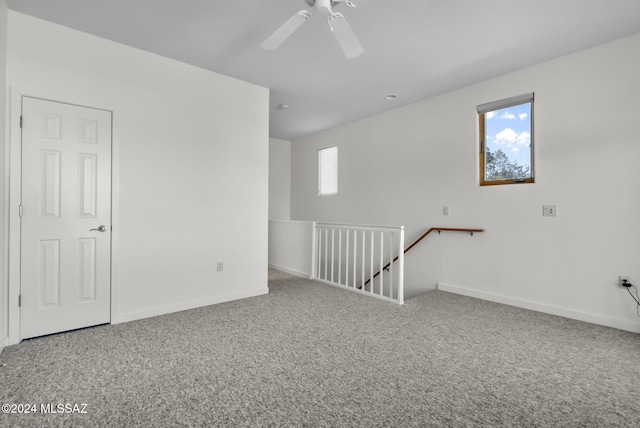 carpeted spare room featuring ceiling fan and a healthy amount of sunlight