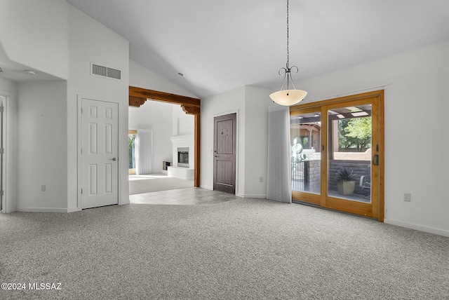 carpeted spare room featuring high vaulted ceiling