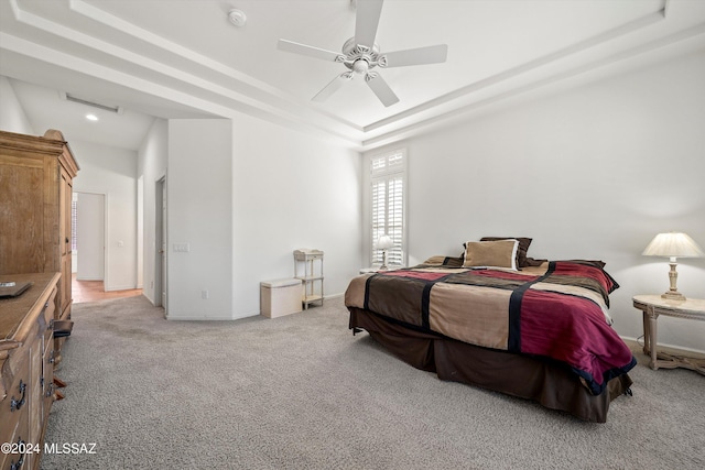 bedroom featuring a tray ceiling, ceiling fan, and light carpet