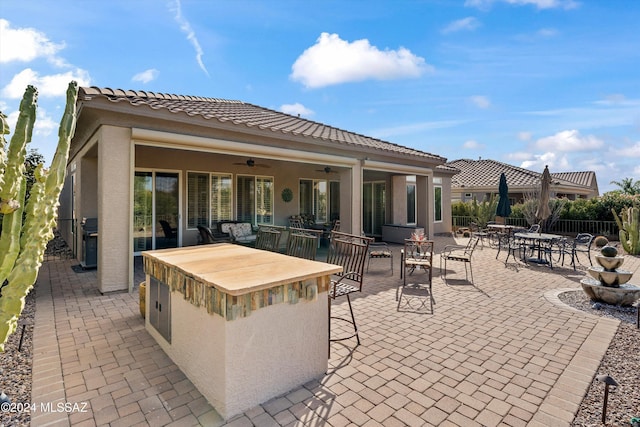 view of patio / terrace with grilling area, ceiling fan, and exterior bar