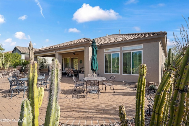 back of house with ceiling fan and a patio area