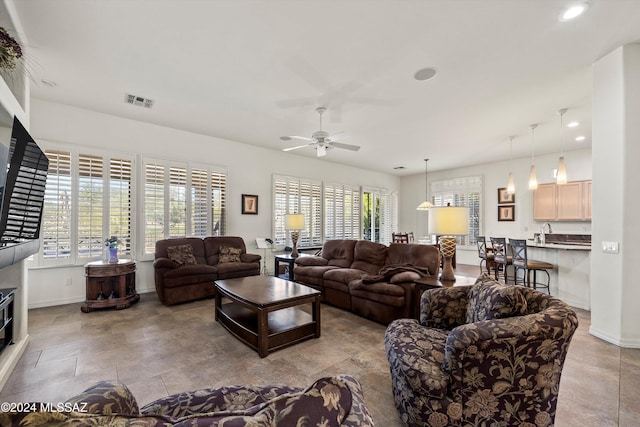 living room with ceiling fan, plenty of natural light, and sink