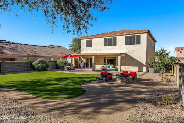 rear view of property featuring an outdoor living space with a fire pit, cooling unit, a patio area, and a lawn