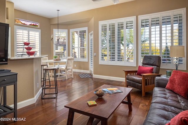 living room featuring dark wood-type flooring and a notable chandelier