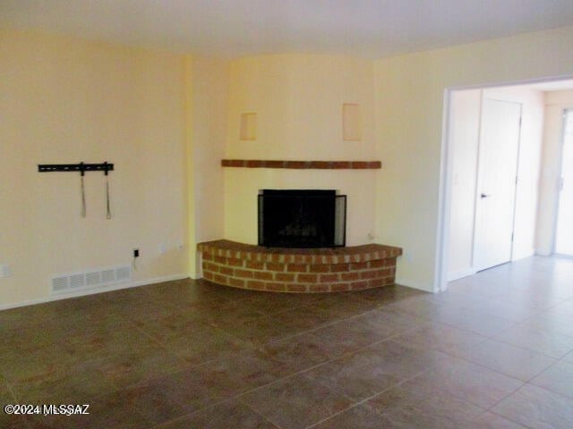 unfurnished living room featuring a brick fireplace