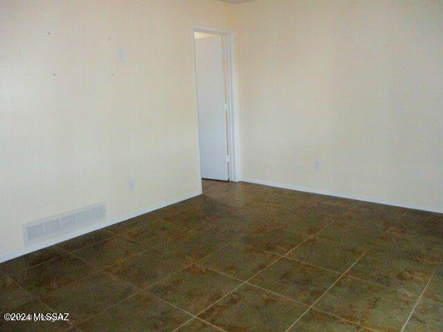 unfurnished room with dark tile patterned floors