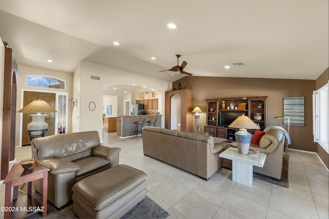 tiled living room featuring plenty of natural light, ceiling fan, and lofted ceiling