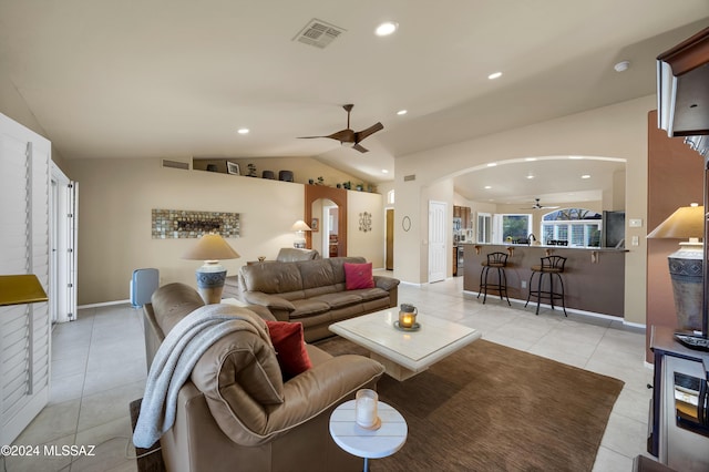 living room featuring ceiling fan, light tile patterned floors, and vaulted ceiling