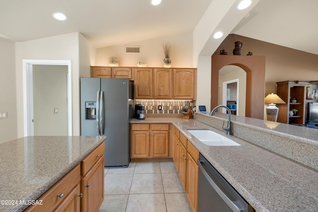 kitchen with lofted ceiling, backsplash, sink, light tile patterned floors, and appliances with stainless steel finishes