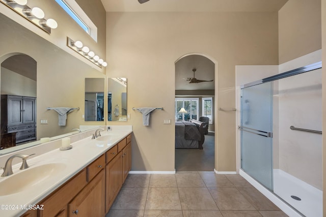 bathroom featuring ceiling fan, tile patterned flooring, and a high ceiling