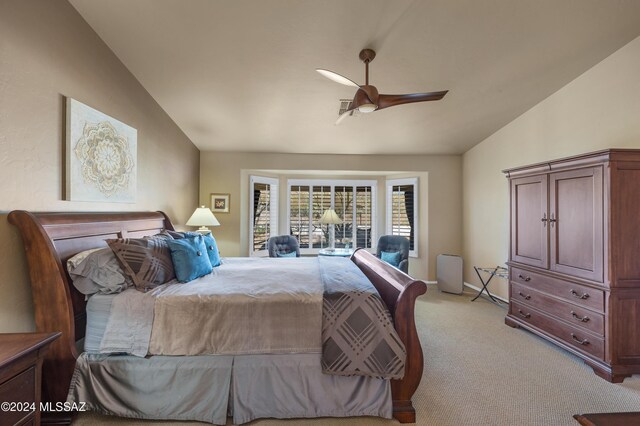 carpeted bedroom with ceiling fan and vaulted ceiling