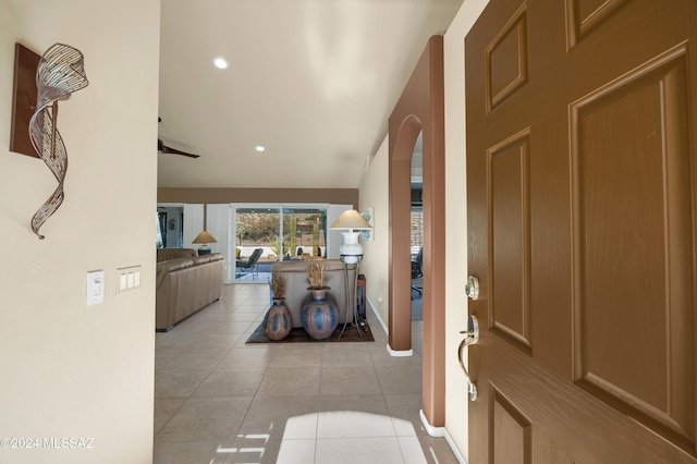 foyer entrance with ceiling fan, light tile patterned floors, and lofted ceiling