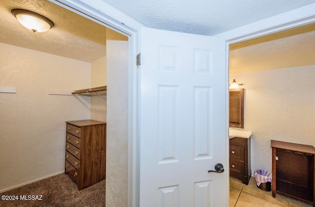 walk in closet with light tile patterned flooring