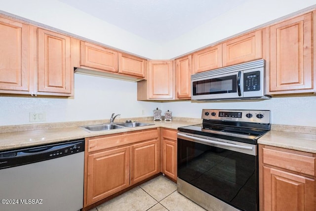 kitchen with sink, light tile patterned floors, stainless steel appliances, and light brown cabinets