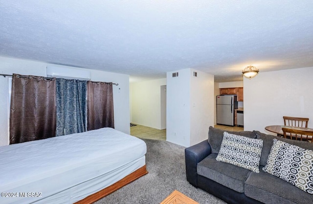 carpeted bedroom featuring a wall unit AC and stainless steel refrigerator