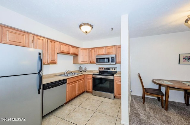 kitchen featuring light tile patterned flooring, appliances with stainless steel finishes, and sink