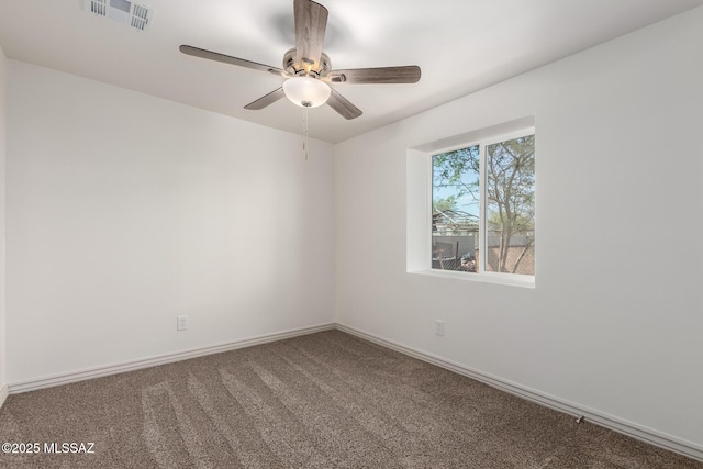 spare room with carpet, visible vents, a ceiling fan, and baseboards