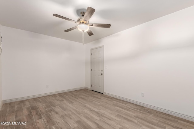 empty room featuring baseboards, light wood-style floors, and ceiling fan