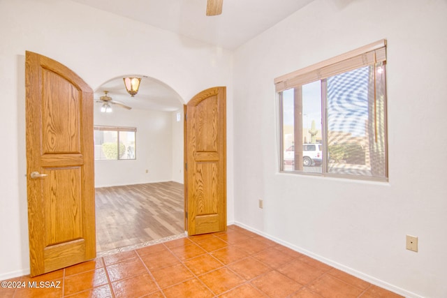 empty room with ceiling fan and light hardwood / wood-style flooring