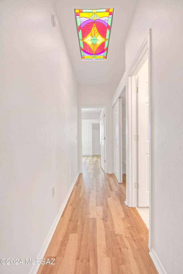 corridor with light hardwood / wood-style flooring