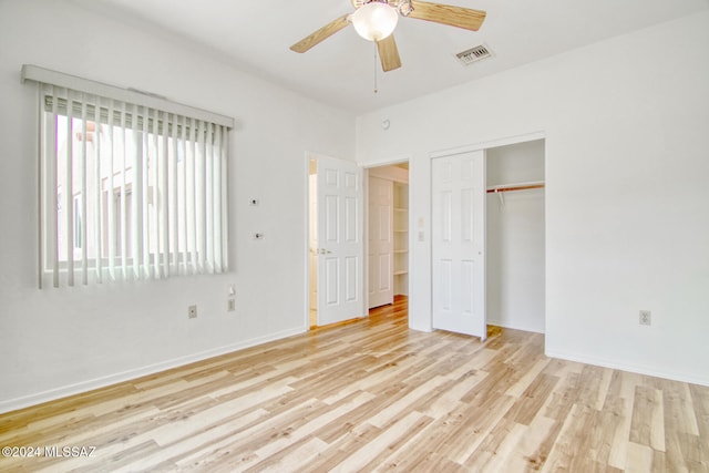 unfurnished bedroom featuring ceiling fan, a closet, and light wood-type flooring