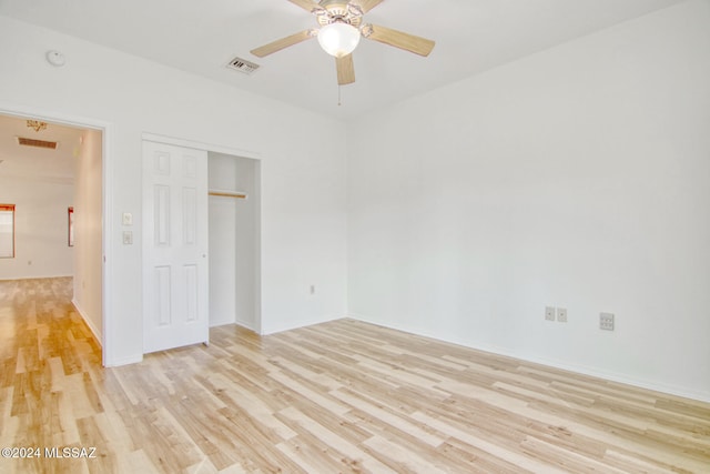 unfurnished bedroom with ceiling fan, a closet, and light wood-type flooring