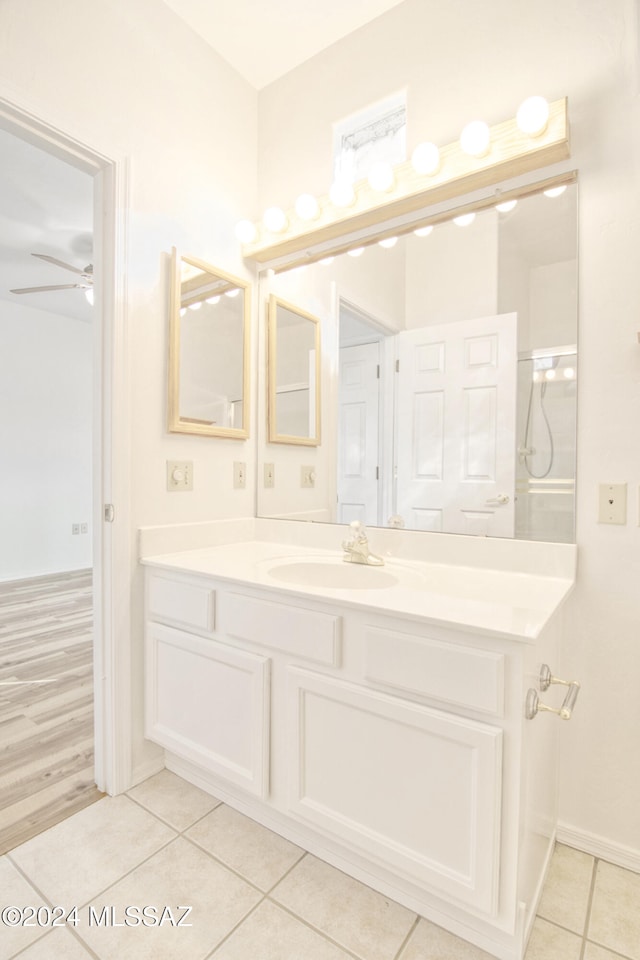 bathroom with tile patterned floors, vanity, ceiling fan, and a shower