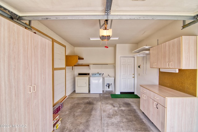 garage with separate washer and dryer and a garage door opener