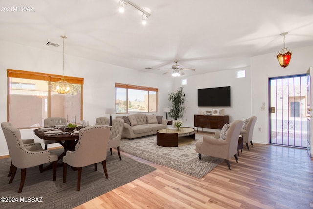 living room with hardwood / wood-style floors and ceiling fan with notable chandelier