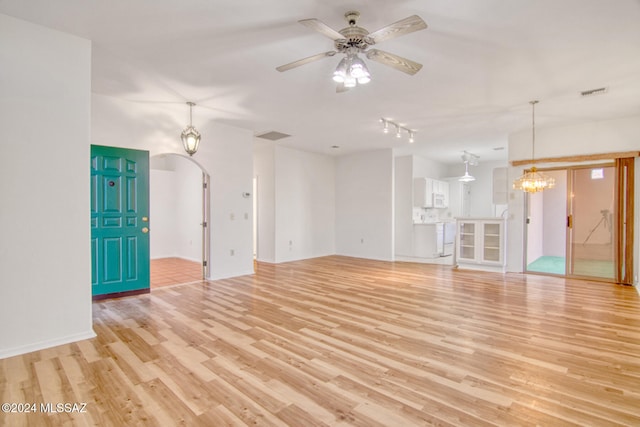 unfurnished living room with light hardwood / wood-style floors and ceiling fan with notable chandelier