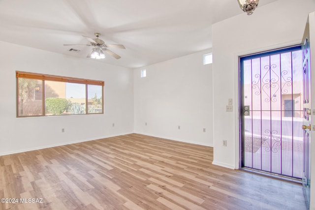 empty room with ceiling fan and light hardwood / wood-style flooring