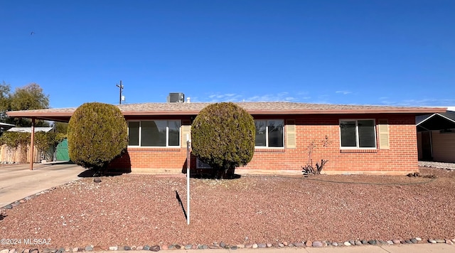 ranch-style house with a carport and central air condition unit