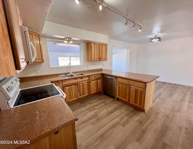 kitchen featuring dishwasher, track lighting, white range, light wood-type flooring, and kitchen peninsula