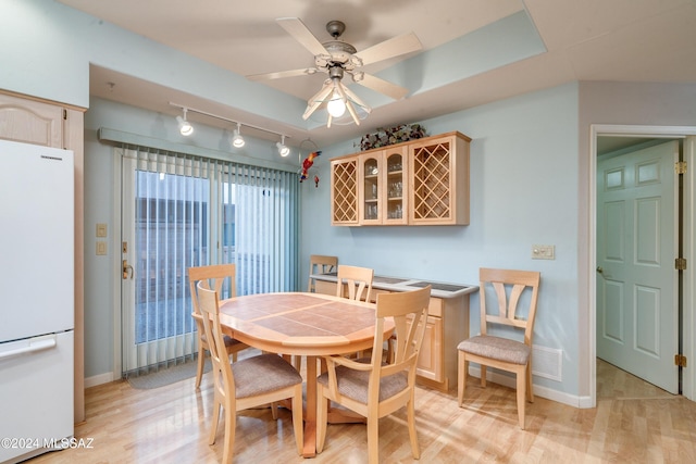 dining room with ceiling fan, rail lighting, and light hardwood / wood-style floors