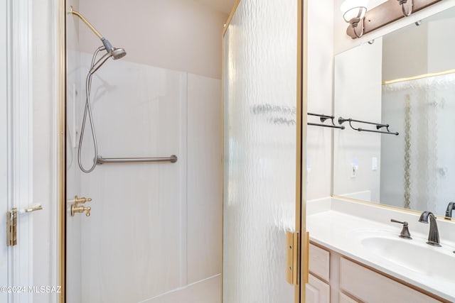 bathroom featuring a shower and vanity