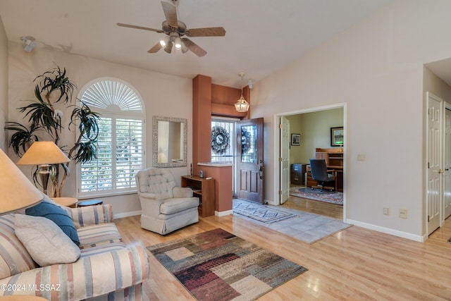 living room featuring ceiling fan, vaulted ceiling, and light hardwood / wood-style flooring