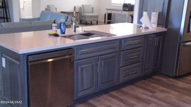 kitchen featuring light countertops, stainless steel appliances, a sink, and open floor plan