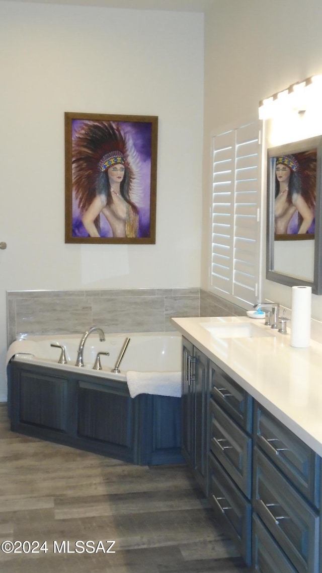 bathroom featuring hardwood / wood-style floors, vanity, and a washtub