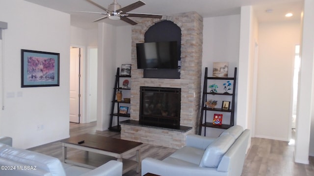 living room featuring a fireplace, hardwood / wood-style flooring, and ceiling fan