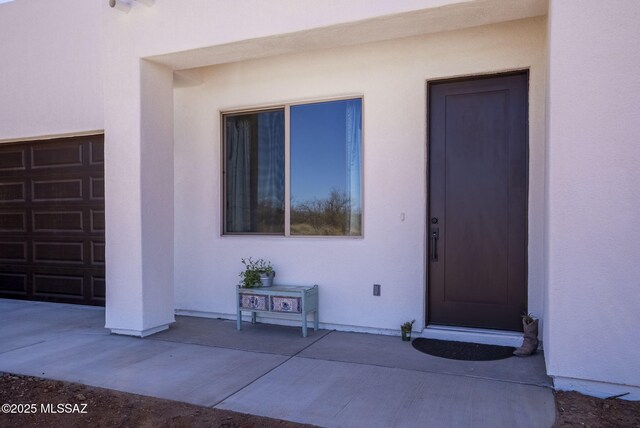 view of front of home with a garage and stucco siding