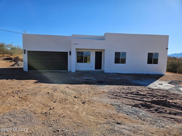 view of front facade with an attached garage and stucco siding