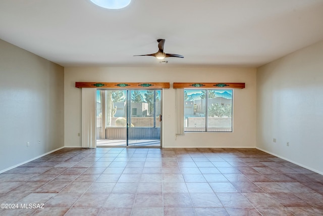 tiled empty room featuring ceiling fan