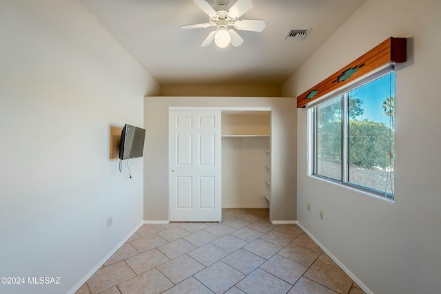 unfurnished bedroom featuring ceiling fan, a closet, and light tile patterned flooring