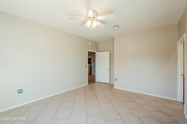 empty room with ceiling fan and light tile patterned floors